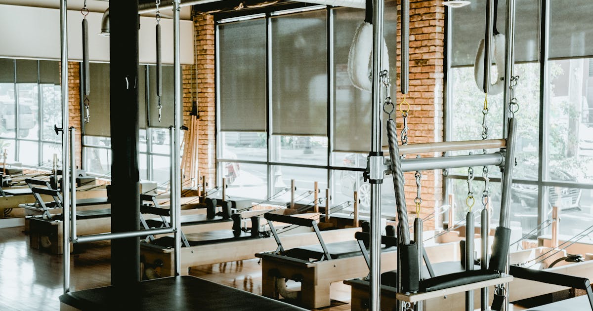 Spacious modern Pilates studio with reformers and well-organised fitness equipment