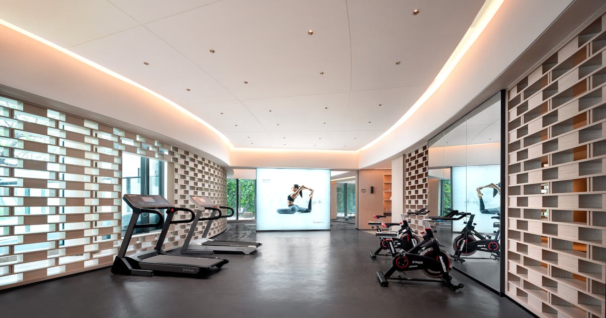 Sleek modern gym interior with treadmills, stationary bikes, and technology-focused design