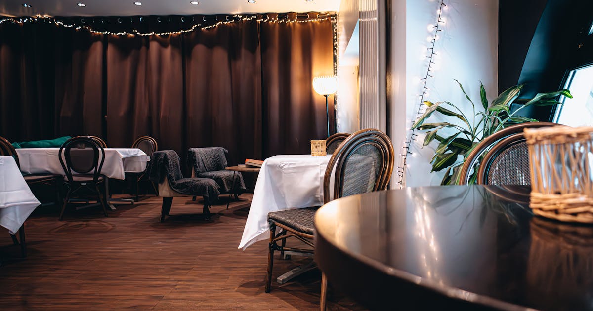 Warmly lit premium restaurant interior with elegant wood decor and ambient lighting