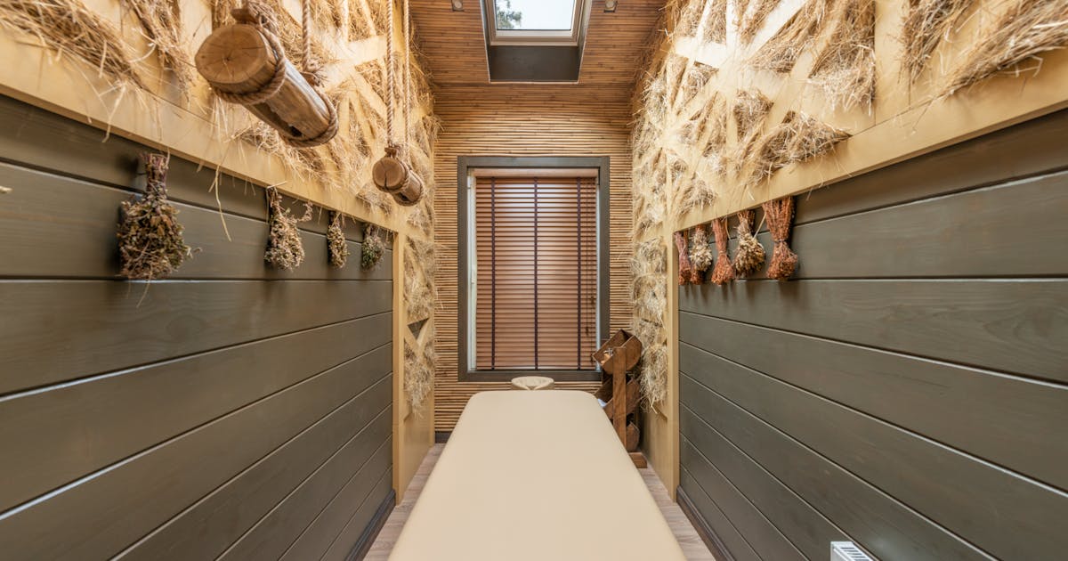 Contemporary luxury spa treatment room with massage bed and organic decor